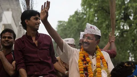 Getty Images AAP leader Arvind Kejriwal waves as he rides on an open jeep during a rally 9 May 2014 in Varanasi