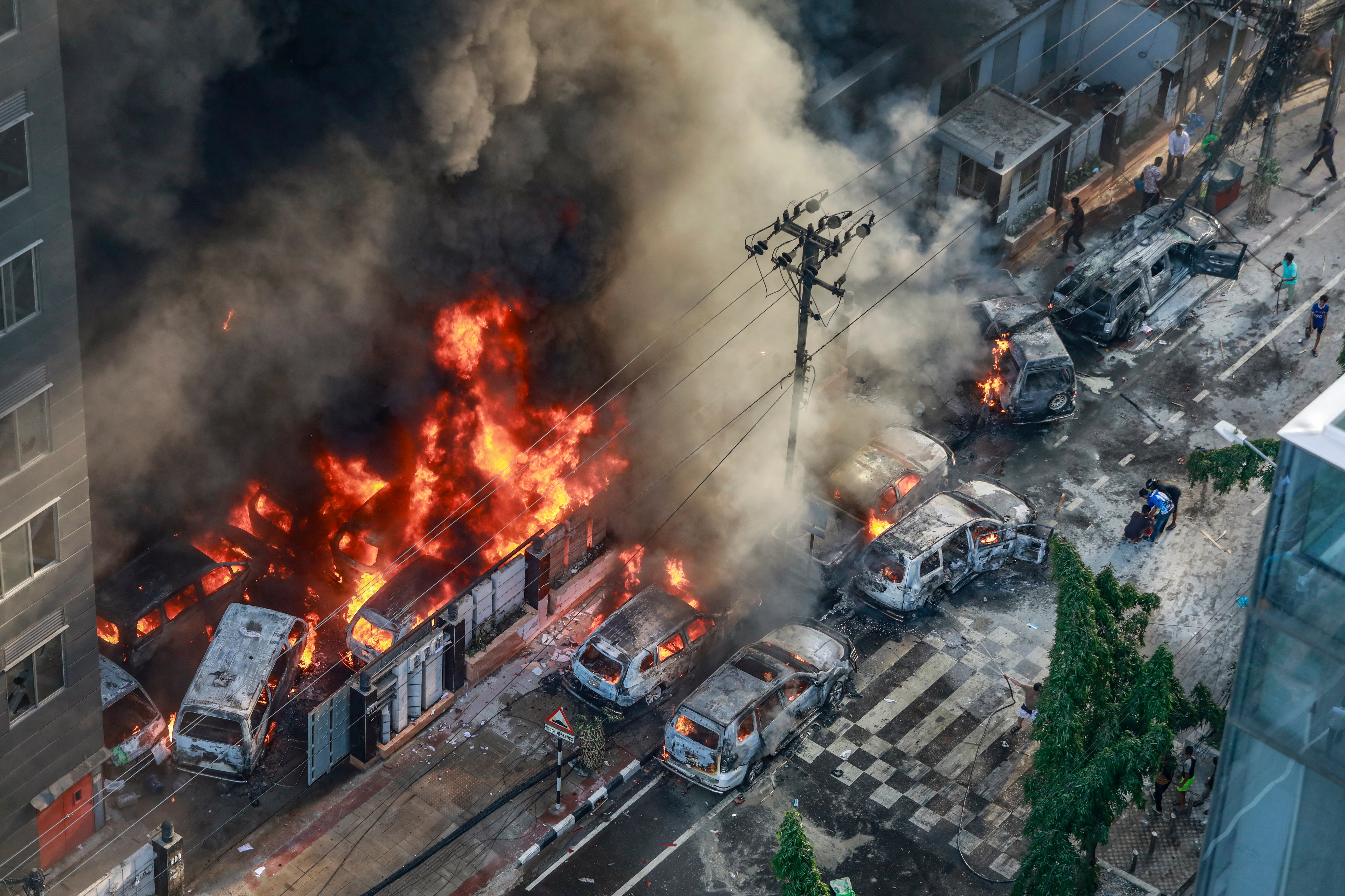 Smoke rises from the burning vehicles after protesters set them on fire near the Disaster Management Directorate office