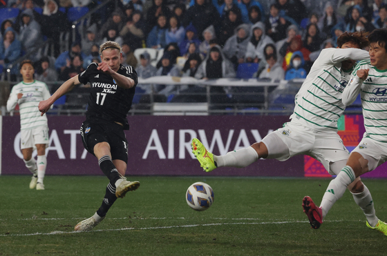 Ulsan HD's Gustav Ludwigson, left, shoots during the second leg of the 2023-24 AFC Champions League quaterfinals against Jeonbuk Hyundai Motors at Ulsan Munsu Football Stadium in Ulsan on March 12. [YONHAP]