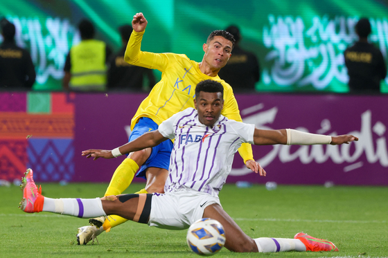 Al Ain defender Saeed Juma, front, vies for the ball with Al-Nassr forward Cristiano Ronaldo during an AFC Champions League match at Al-Awal Park Stadium in Riyadh, Saudi Arabia on March 11. [AFP/YONHAP] 