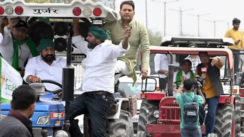 Getty Images Demonstrators on tractors travel along the Yamuna Expressway during a protest organized by farmers in Noida, India, 26 February 2024