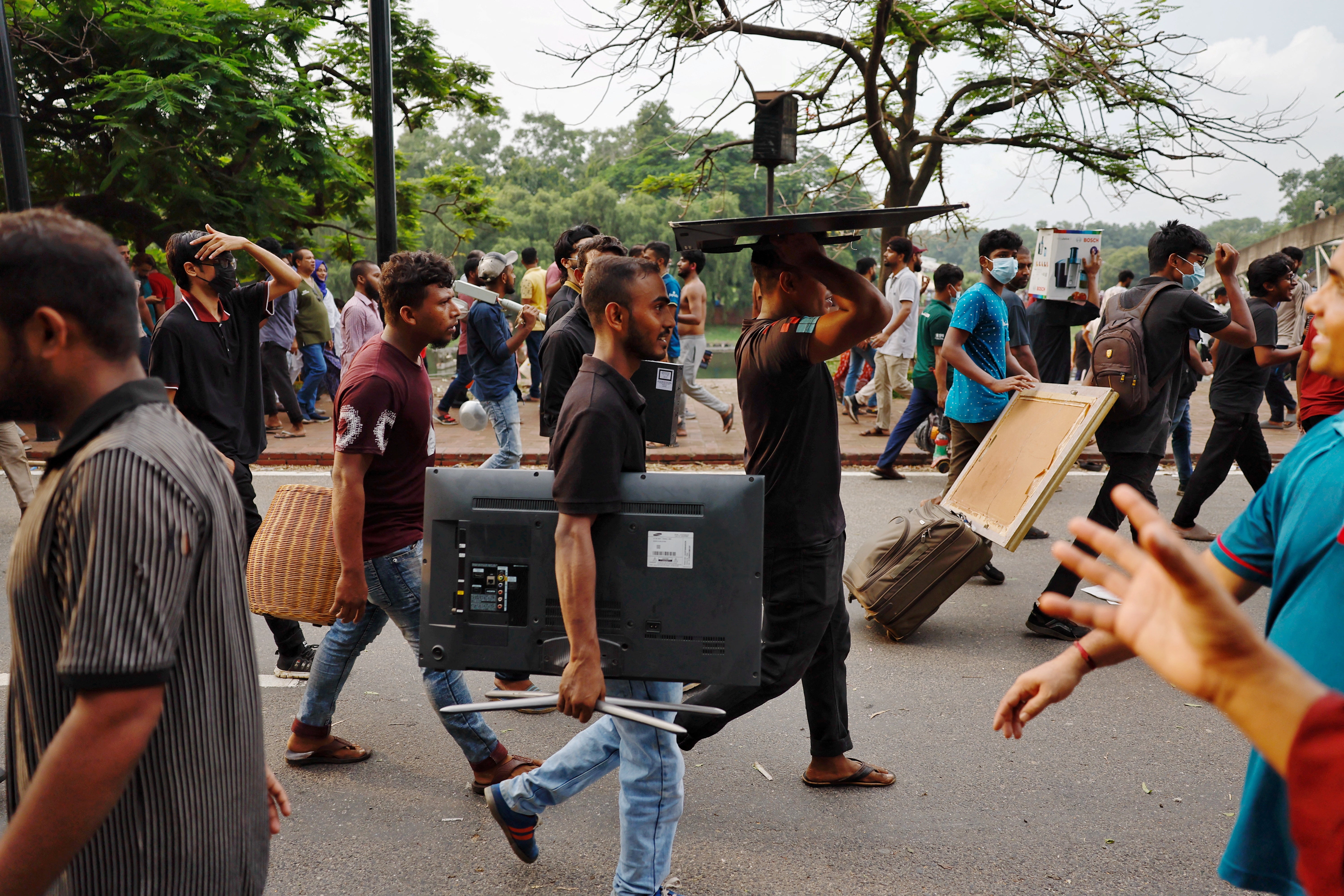 People carry looted items from the Ganabhaban, the prime minister's residence in Dhaka