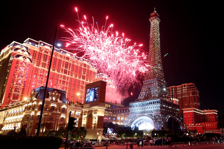 Fireworks explode over a casino and replica of the Eiffel Tower. 