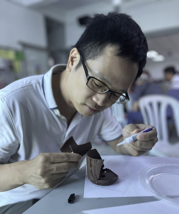 Johnston Seah, a member of the Pasir Panjang Church of Christ in Singapore, repairs a broken clay jar during a kintsugi project at the Respite retreat. Kintsugi is the Japanese art of putting broken pottery pieces back together with gold. Retreat participants used super glue and gold paint.