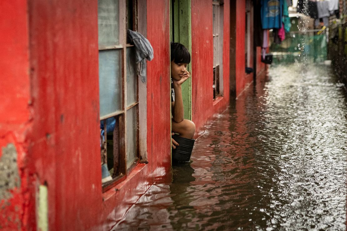 A child looks out from a flooded home amid heavy rains brought by Tropical Storm Yagi in Pampanga, Philippines, September 5, 2024.