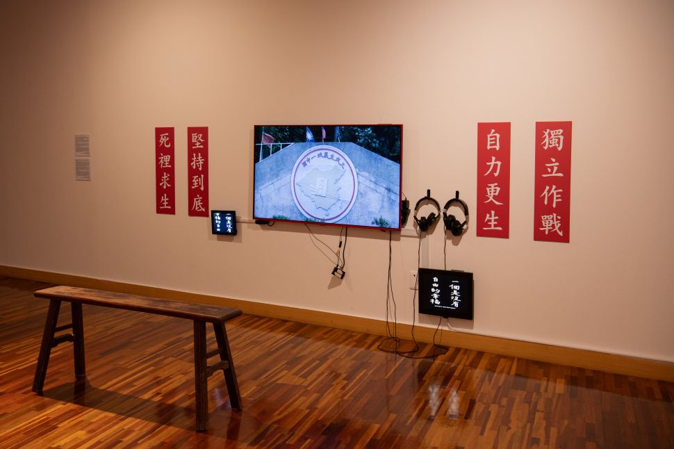 Image of a video instalaltion with chinese glags on the side.