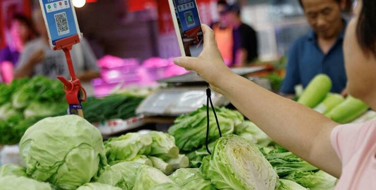 A customer scans a QR code to pay for vegetables at a morning market in Beijing, China, Aug. 9, 2023. Reuters-Yonhap