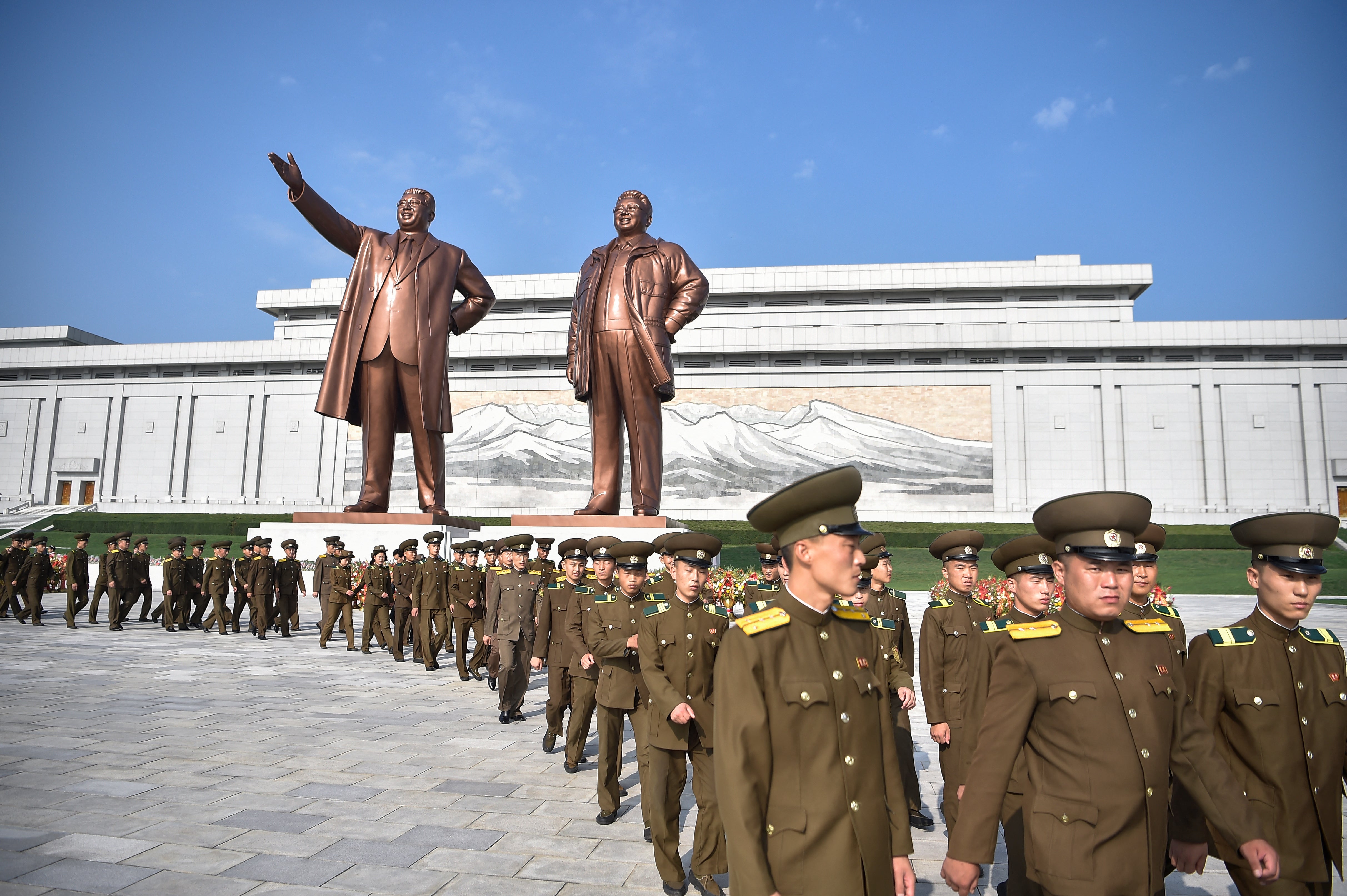 Service personnel of the public security ministry pay tribute as they visit the statues of late North Korean leaders Kim Il Sung and Kim Jong Il at Mansu Hill in Pyongyang