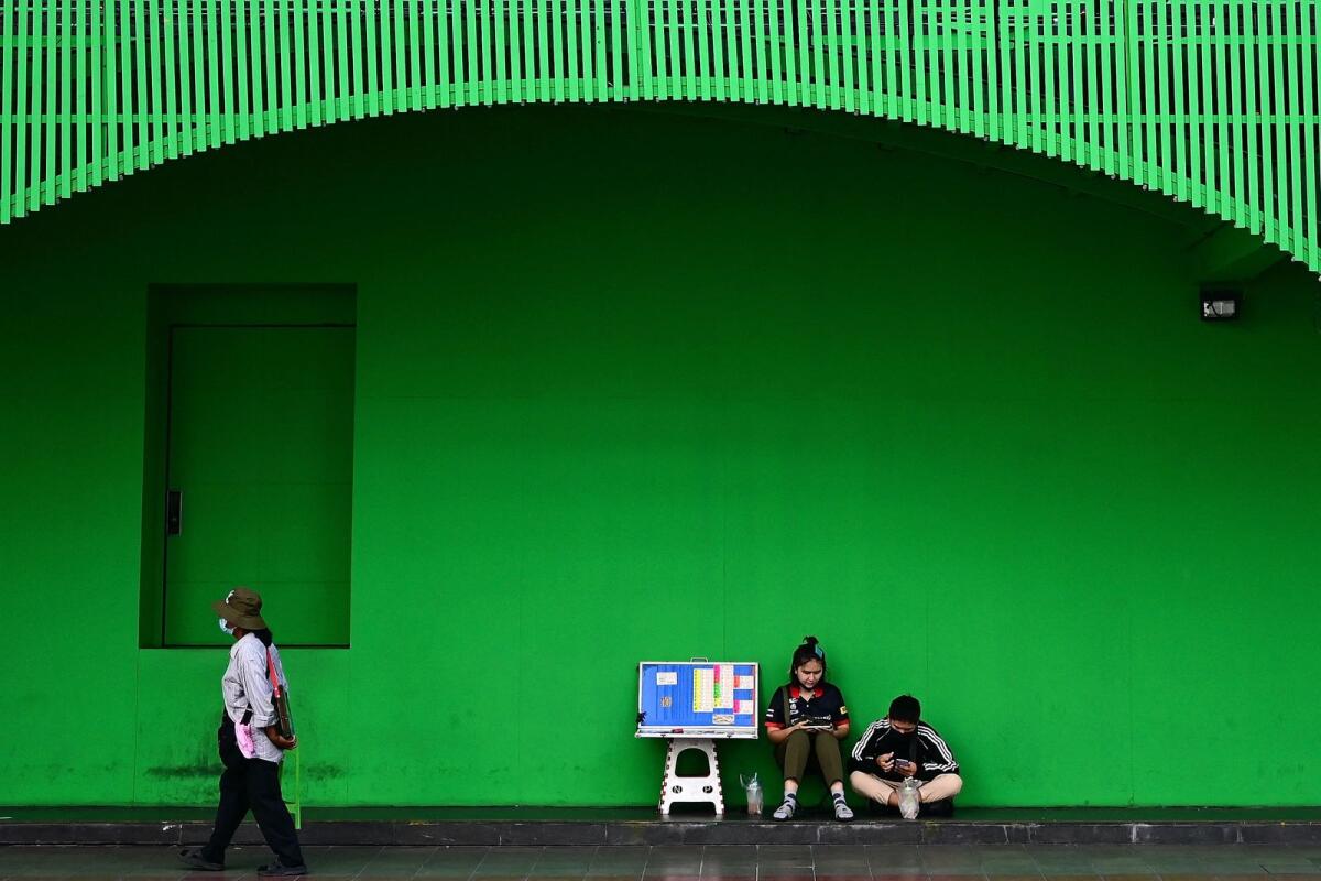 Vendors selling lottery tickets wait for customers along a street in Bangkok. Only some gambling is permitted, such as state-controlled horse races and an official lottery. — AFP